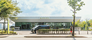 밴 한 대가 건물 앞에 주차되어 있어 건축물을 배경으로 외관을 드러내고 있습니다.