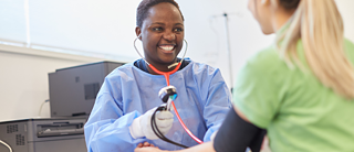A nurse measures a woman's blood pressure