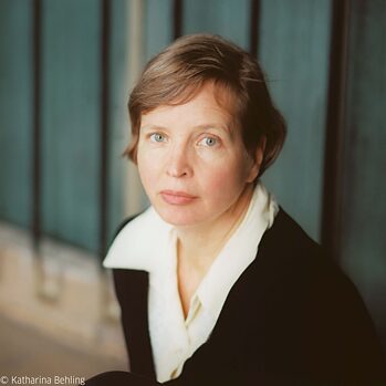 Foto af Jenny Erpenbeck. Hun ser på kameraet fra siden. Der er alvor i hendes blik.