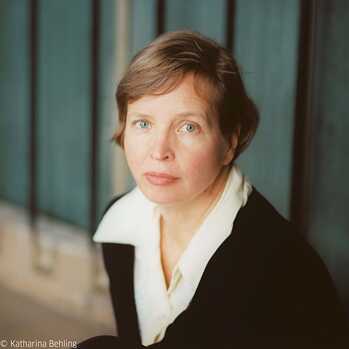 Foto af Jenny Erpenbeck. Hun ser på kameraet fra siden. Der er alvor i hendes blik.