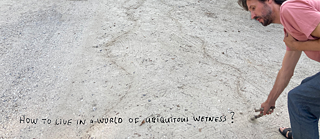 men drawing in sand. written text: How to live in a world of umiquitous wetness?