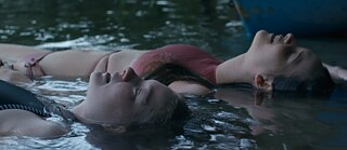 Zwei Mädchen treiben auf einem See.