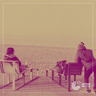 Drei Leute schauen auf Meer