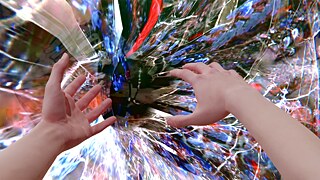 Auf dem Bild sieht man zwei Hände, die so aussehen, als würden sie nach etwas greifen wollen. Im Hintergrund sieht man verschiedene Farben in einer Art Sog. 