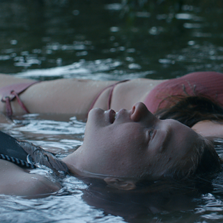 Zwei Mädchen treiben auf einem See.