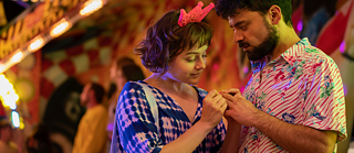 Franky betrachtet die Hände eines Jungen auf einem Jahrmarkt.