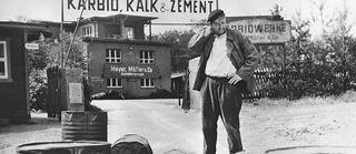 Schwarz-weiß Bild: Mann vor Fabrik