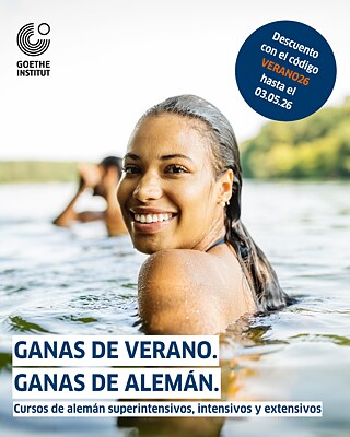 Una mujer joven est´a nadando en un lago, mira sonriendo a la cámera