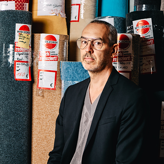 Autor Marc Langhuß vor Teppichrollen