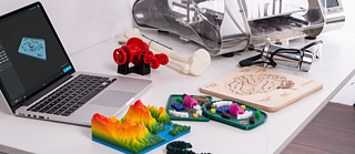 Escritorio con una laptop y elementos de impresión 3d