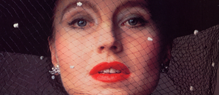 Retrato de María Braun con sobrero negro con velo y labios pintados de rojo