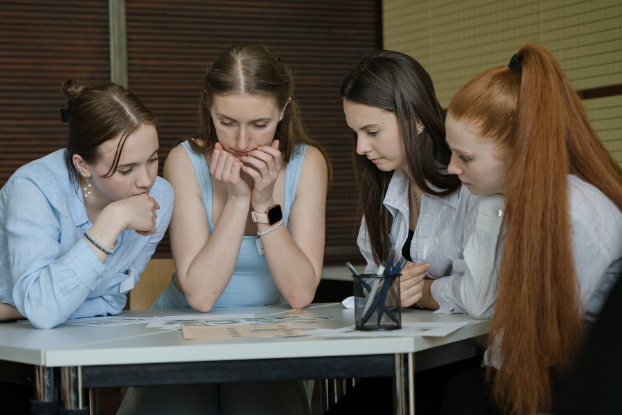 Während eines Sprachkurses sitzen mehrere Teilnehmer an einem Tisch.