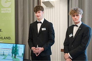 Zwei Teilnehmer stellen ihr Projekt im Bereich der Informatik vor. Einer von ihnen spricht.