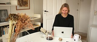 Eine Deutschlehrerin sitzt an seinem Computer für einen Online-Kurs.