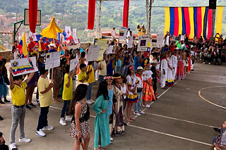 Schüler*innen in landestypischer Kleidung und Flaggen auf einem großen Hof