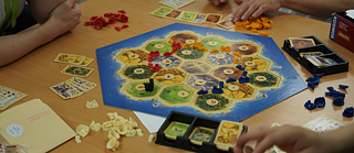 Four people playing Catan