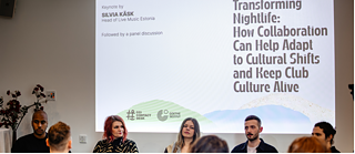 the picture shows a panel discussion with several people seated on stage in front of an audience. A screen behind them reads: Transforming Nightlife: How Collaboration Can Help Adapt to Cultural Shifts and Keep Club Culture Alive. Keynote by Silvia Käsk, Head of Live Music Estonia. Followed by a panel discussion