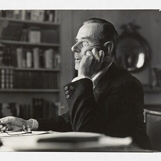 Thomas Mann, Brustbild, Profil nach links, Zigarre in der rechten Hand, Kopf auf die linke Hand gestützt, von der Arbeit aufblickend.