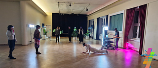 Auf dem Foto sieht man einen Saal, durch den sich mehrere Menschen mit VR-Brillen bewegen