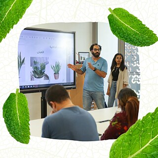 يقف بافلي بجانب لوح ويشرح للحضور أنواع النباتات