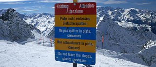 Ein Warnschild am Pistenanfang weist Skifahrer in fünf Sprachen auf die Gefahren durch Gletscherspalten hin.
