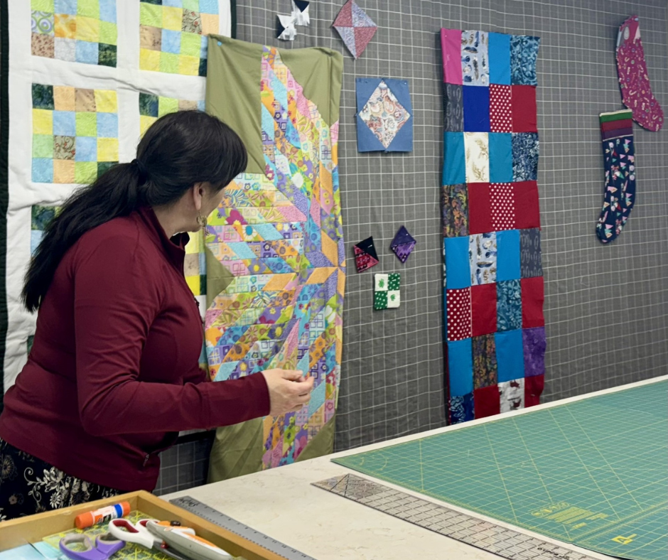 An artist and star quilts that are hung up 