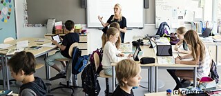 A woman is engaging with a group of attentive students in a bright classroom setting