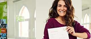 Eine junge Frau zeigt lächelnd und stolz ihr Zertifikat
