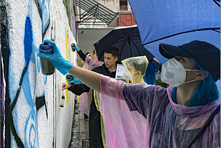 Jugendliche sprühen ein Graffiti.