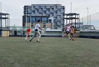 Jugendliche spielen Fußball in einer Großstadt.