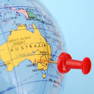 A globe featuring a pin on Australia, emphasizing its unique location in the world map