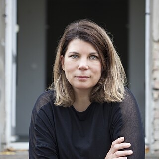 Eine Frau, die in die Kamera blickt