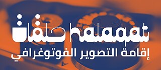 صورة لبرنامج "حلقات" مكتوب بالعربية والإنجليزية على لوحة بألوان برتقالية وزرقاء وخلفها فيلم لكاميرا