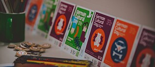 A table covered with various posters, showcasing different designs and themes