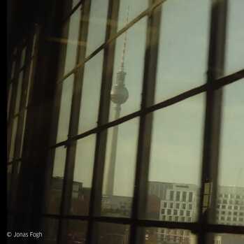 Foto af Fernsehturm i Berlin, taget gennem en rude. Deraf forekommer bygningen lidt sløret.