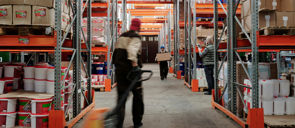 Auf dem Foto sieht man einen Arbeiter in einer riesigen Lagerhalle