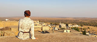 Alfreda is sitting on a roof top and looking at Midin village
