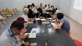 Participants sharing tech-related stories while others capture key points on sticky notes