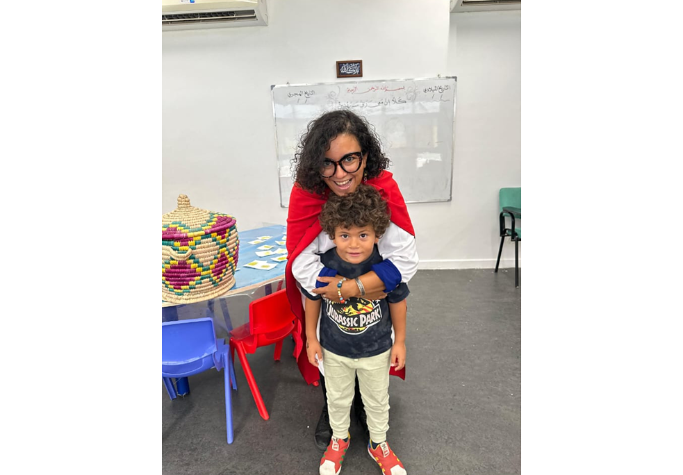 سيدة ترتدي معطف أحمر تقف مع طفل صغير