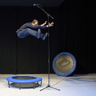 Felix Baumann springt auf einem Trampolin in Richtung eines Mikrofons, das über ihm befestigt wurde.