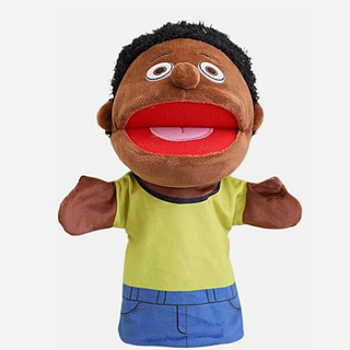 Eine dunkelbraune, männliche Sprechpuppe, die eine blaue Hose und ein gelbes T-Shirt trägt. 