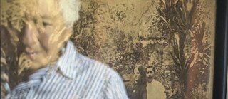 Fadua Elena Fayad reflected in the photograph of her grandfather Farid Naffah and her grandmother Fadua Baruque, Honda, Colombia..