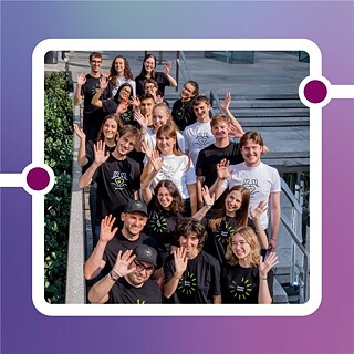 Gruppenfoto der 20 Botschafter*innen der deutschen Sprache, lächelnd und winkend auf einer Treppe in Mailand