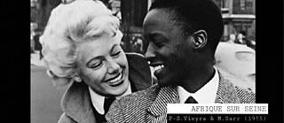 Citation du film Afrique sur Seine (1955) : Une femme blanche, un homme noir se regardent en souriant. Ils portent des vêtements dans le style des années 1950