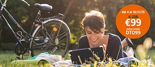 Una ragazza con tablet su un prato verde con il suo tablet, accanto a una bicicletta; in un bollino arancione, prezzo scontato a 99 Euro