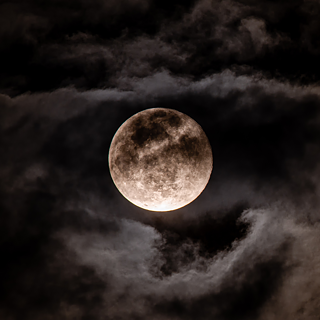 The picture shows a picture of the moon in a clouded sky.