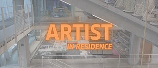 Schriftzug Artist in Residence, im Hintergrund Ansicht vom Innenraum im Kulturzentrum Thoravej 29. 