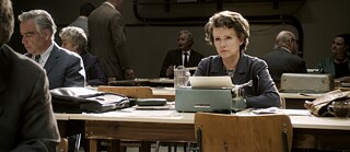 Das Foto zeigt Hannah Arendt sitzend am Schreibtisch.