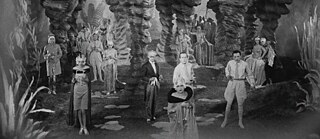 Das Foto ist ein schwarz-weiß Bild und zeigt viele schick gekleideten Leute in einer Art Höhle unter der Erde.