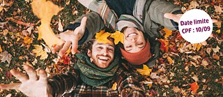 Luftaufnahme von zwei Personen, die auf einer mit bunten Herbstblättern bedeckten Wiese liegen. Mehrere Blätter liegen auf ihrer Kleidung und in ihrer Umgebung, einige werden in die Luft geworfen. Die Hände der Personen sind zur Kamera ausgestreckt. Rechts oben ist ein weißer Kreis mit violetter Schrift zu sehen, auf dem steht: „Date limite CPF : 10/09“.